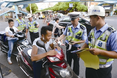 昨天下午，交警在市區城開天橋下管理電動車。蔣文廣 攝