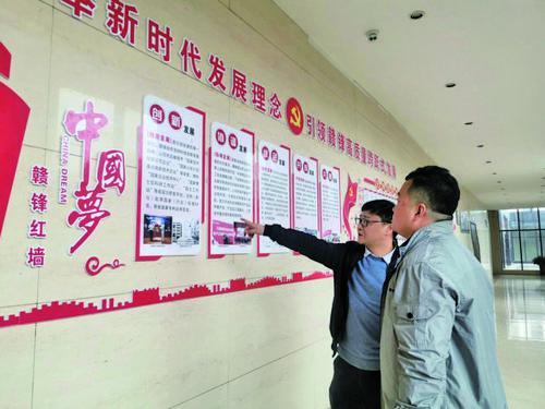 贛鋒鋰業(yè)黨總支書記黃韶勇（左）向記者介紹黨建工作有關(guān)情況